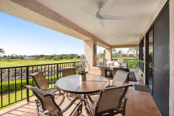 Balcony dining area features table, chairs, railings, palms, and views