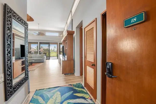 Island entry welcomes with artwork, seating, windows, and tropical views