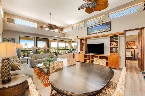 Living and dining space combines sofas, table, windows, artwork, and lighting