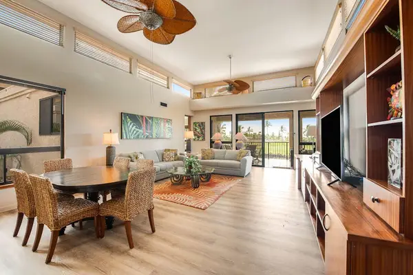 Open concept interior connects kitchen, dining, seating, windows, and artwork
