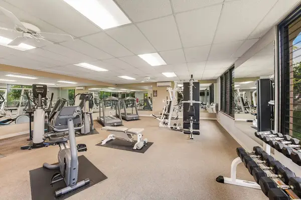 Resort fitness center features equipment, mirrors, windows, flooring, and lighting