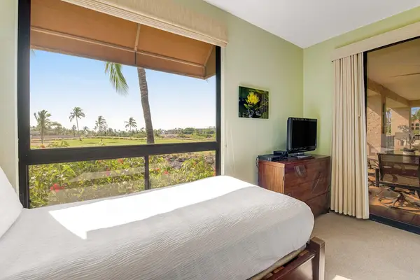 Bedroom windows overlook tropical landscapes, palms, daylight, and resort grounds