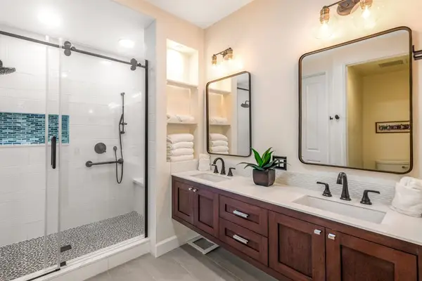 Master bathroom with double sinks and an updated walk-in shower.