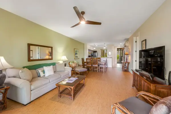 Large living room with a sofa bed, flat screen tv and lanai access and open to the dining room and kitchen - for the open concept feel.