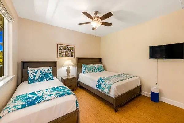 Guest room with queen bed, twin bed and a flat screen tv.