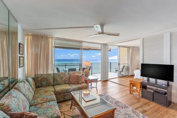 Living room with sofa bed, flat screen tv and rays of natural light streaming in from the lanai.