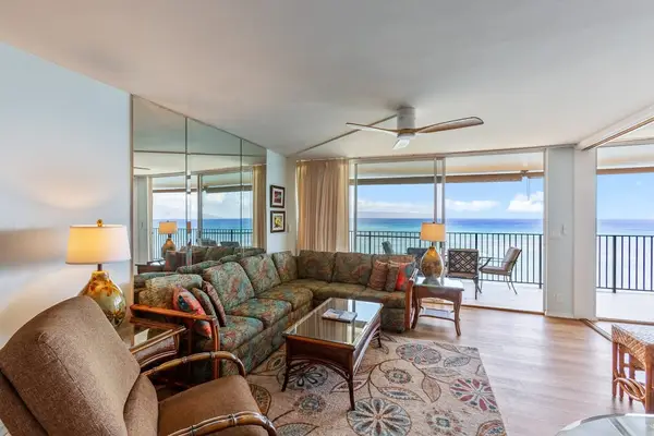 Living room with sofa bed, flat screen tv and rays of natural light streaming in from the lanai.