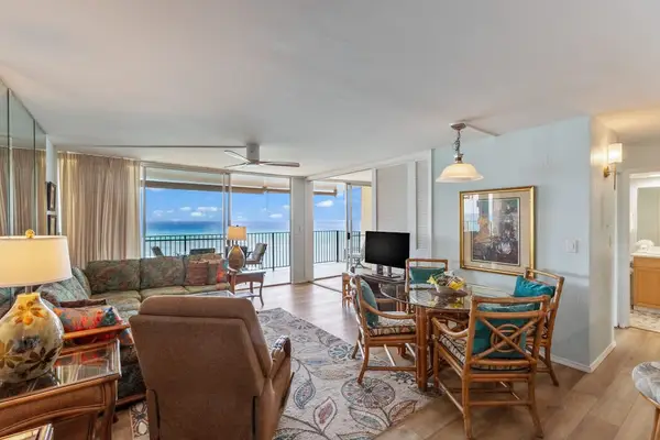 Living room with sofa bed, flat screen tv and rays of natural light streaming in from the lanai.