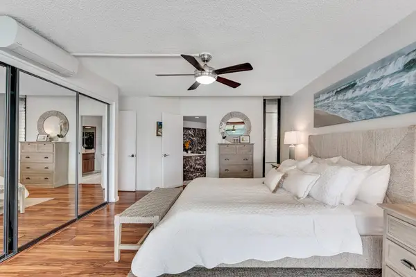 Primary bedroom with mirrored closets, spacious and full of natural light