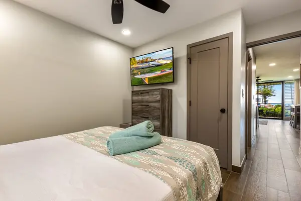 Spacious master bedroom with king bed with a flat screen tv.