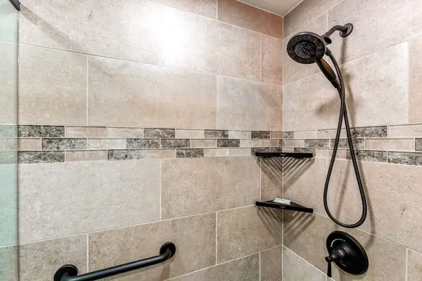 Newly remodeled master bath with two sinks and a spacious tiled walk-in shower.
