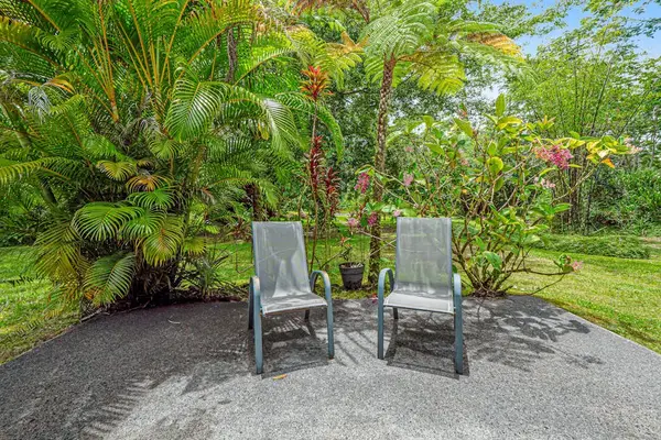 Escape to a private tropical backyard oasis surrounded by lush Hawaiian landscaping, swaying palms, and the peaceful beauty of paradise.