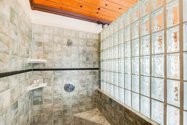 Walk-In Stone Shower with Glass Block Wall & Built-In Bench