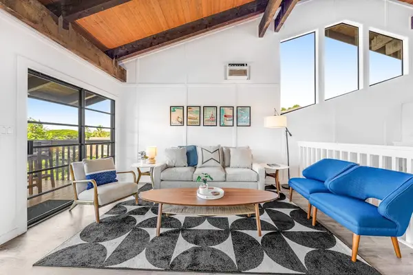Blue sofa lounge opens onto breezy balcony and island views