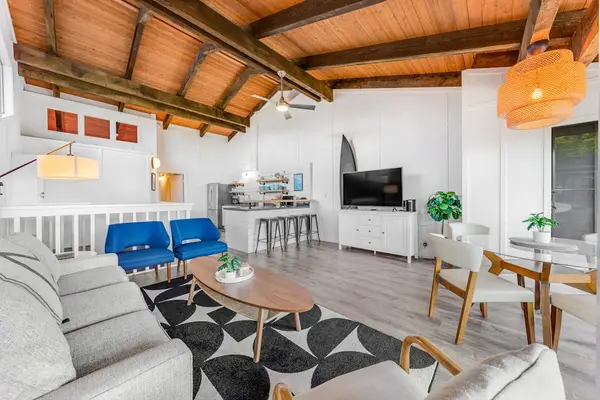 Open concept lounge blends blue seating dining and bright kitchen