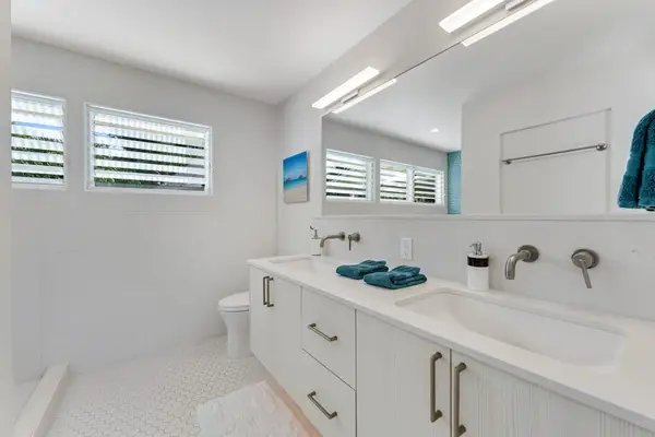 Updated bathroom includes polished fixtures, mirror space, and tiled surfaces
