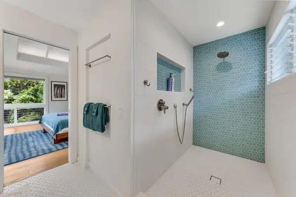Comfortable bathroom features a shower, mirror, and neatly finished walls