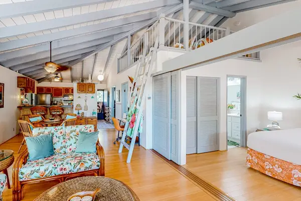 Open living area shows colorful seating, entryway, artwork, and windows
