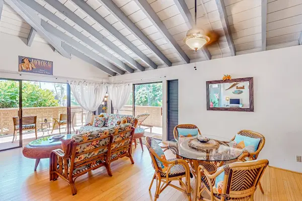 Airy living area features woven seating, artwork, and garden views
