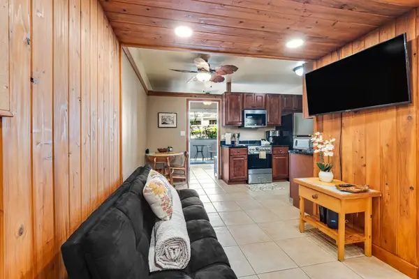 The interior is compact but thoughtfully designed, offering a sitting area with a TV, a bistro dining space, and a well-equipped kitchen with all-new stainless steel appliances and maple cabinetry.