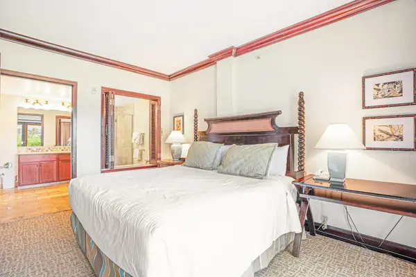 Spacious primary bedroom with an en suite bathroom and sliding glass doors that fill the room with natural light and provide easy outdoor access.