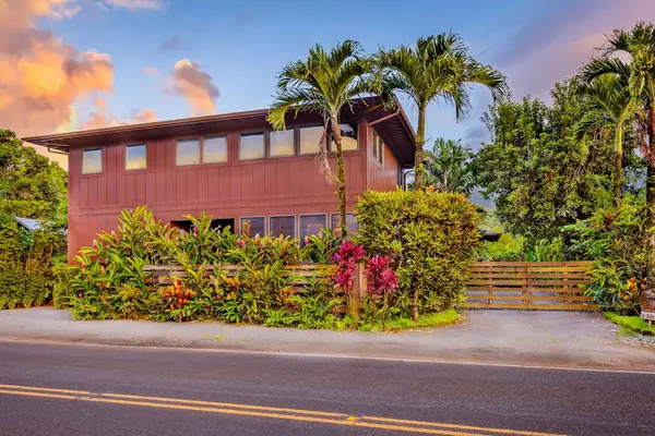 Home exterior showcases tropical landscaping, palms, and welcoming street access