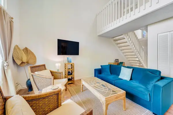 Open concept living room with abundant natural light and a flat screen tv.