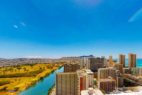 High-angle vantage point showcasing the turquoise Ala Wai Canal, the Ala Wai Golf Course, Diamond Head monument, and the surrounding ocean.