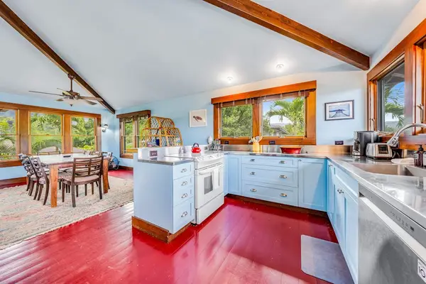 Blue kitchen features a breakfast bar, white cabinetry, and appliances