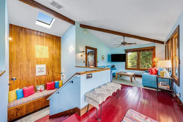 Living room features blue walls, wooden accents, and comfortable seating