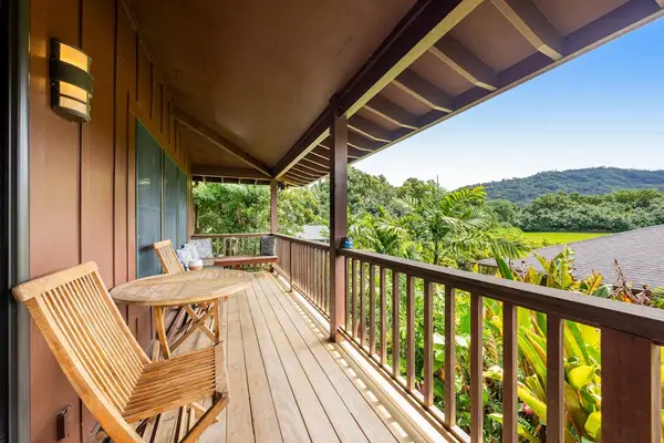 Covered balcony features rocking chairs, scenic hills, and fresh breezes