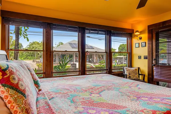 Bright bedroom showcases colorful bedding, wood accents, and ceiling fan