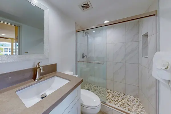 Private bathroom with a convenient shower and mirror, located right inside the bedroom for added privacy