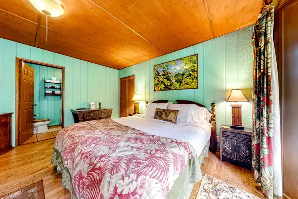 Guest room with a queen bed and large picture windows.