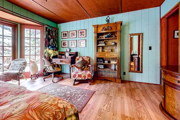 Guest room with a queen bed and large picture windows.