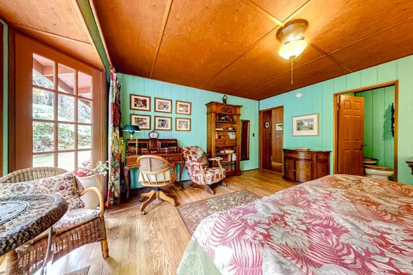Guest room with a queen bed and large picture windows.