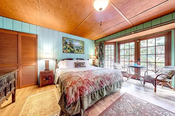 Guest room with a queen bed and large picture windows.