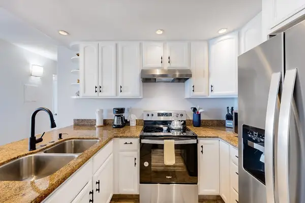 This kitchen features modern stainless steel appliances and white cabinetry.