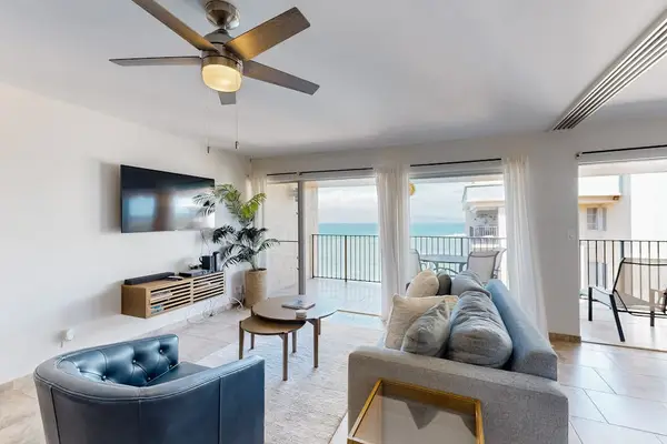 Bright living room with a balcony and a view of the ocean.