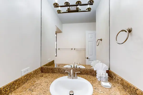 This bathroom features a beige granite countertop with a small, white undermount sink.