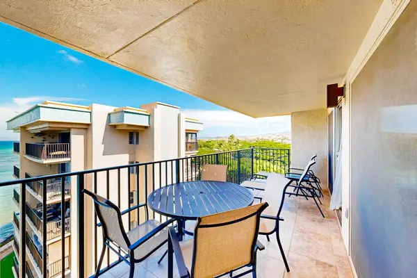 Private balcony featuring a black metal dining set with sweeping ocean views.