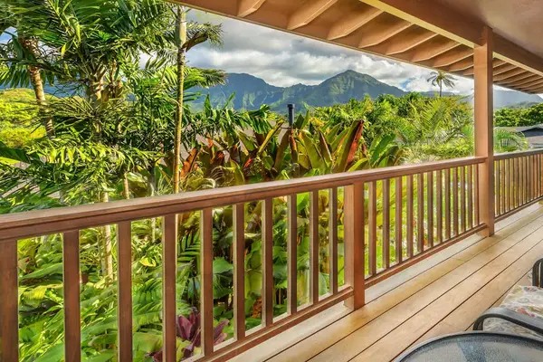 Covered balcony overlooks lush tropical foliage and dramatic mountain scenery