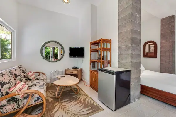Intelligent spatial design. A textured stone column cleanly partitions the sleeping quarters from a private lounge area featuring woven accents and clean circular mirrors. 📐🪨