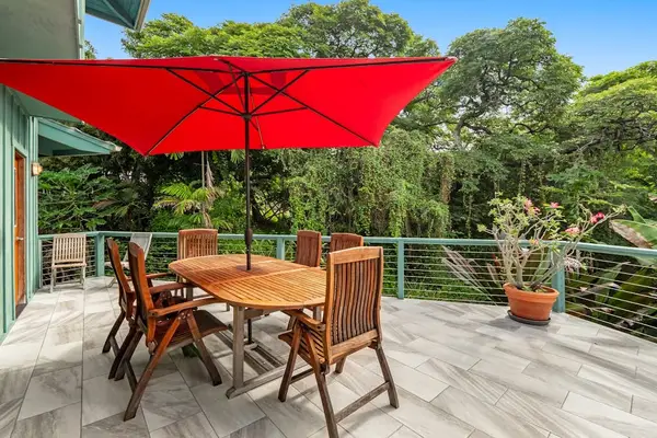 Immersive canopy dining. An oval wooden table sets a geometric anchor against the expansive treetop horizon, sheltered by a broad crimson canopy. 🌳☀️