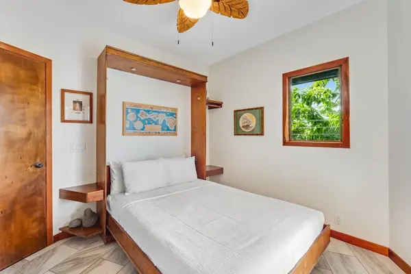 Wake up to paradise! This cozy bedroom offers a plush bed, beautiful custom wood details, and peaceful views of lush greenery! 🛌✨🌴
