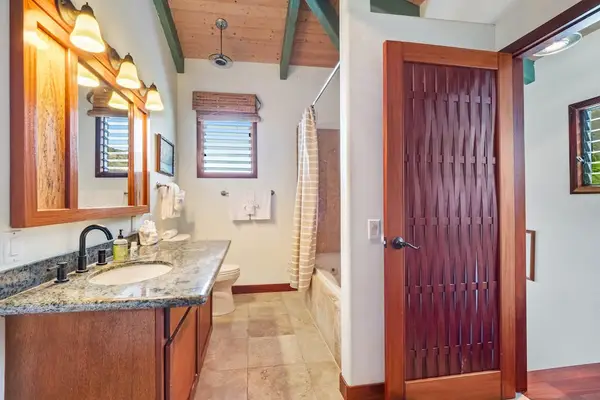 Spacious and elegant! This primary bathroom features a stone-top vanity with warm lighting, a modern shower, and gorgeous custom wood detailing! 🚿🪵✨