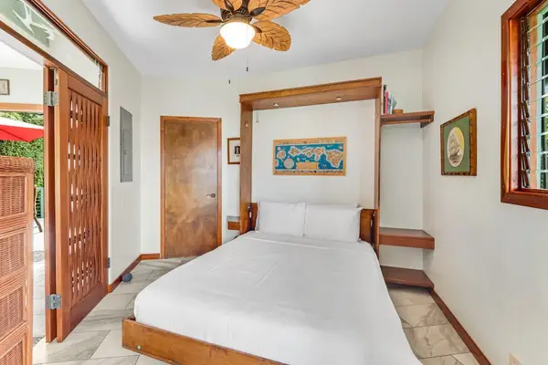 Rest easy in this spacious queen bedroom featuring a plush bed, cool ceiling fan, and ample built-in wooden closet space! 🛌🌀🪵