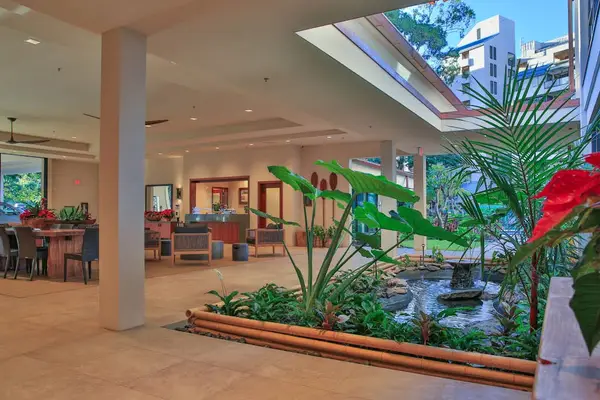 Bright open-air lobby surrounded by tropical landscaping