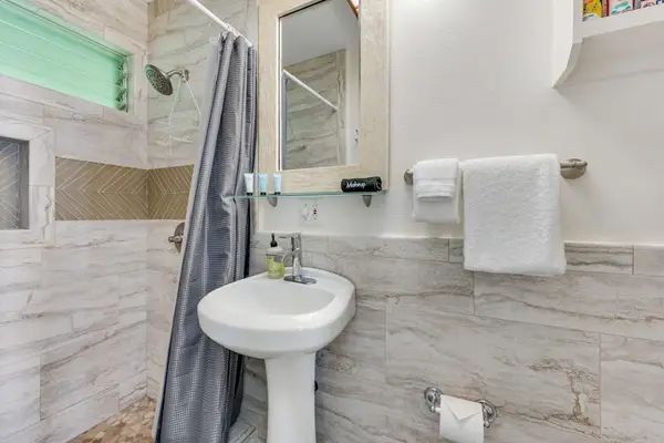 Bright full bathroom with a walk-in shower and fresh towels.