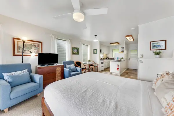 Bright bedroom with a comfortable seating area and open layout.